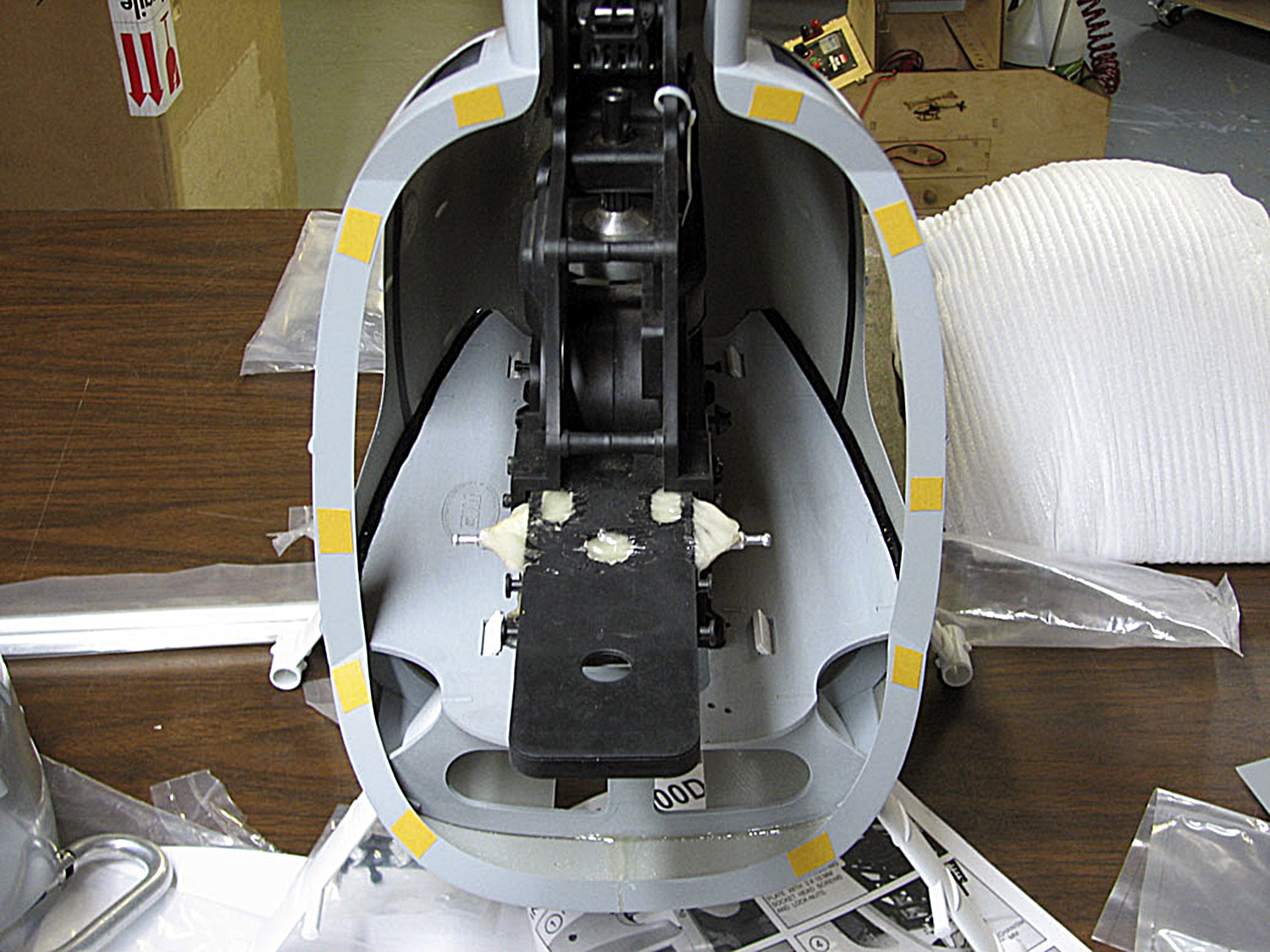 Photo showing squares of yellow double-stick tape used to temporarily secure the nose cone of the Funkey-brand Hughes 500 fuselage to the main fuselage section