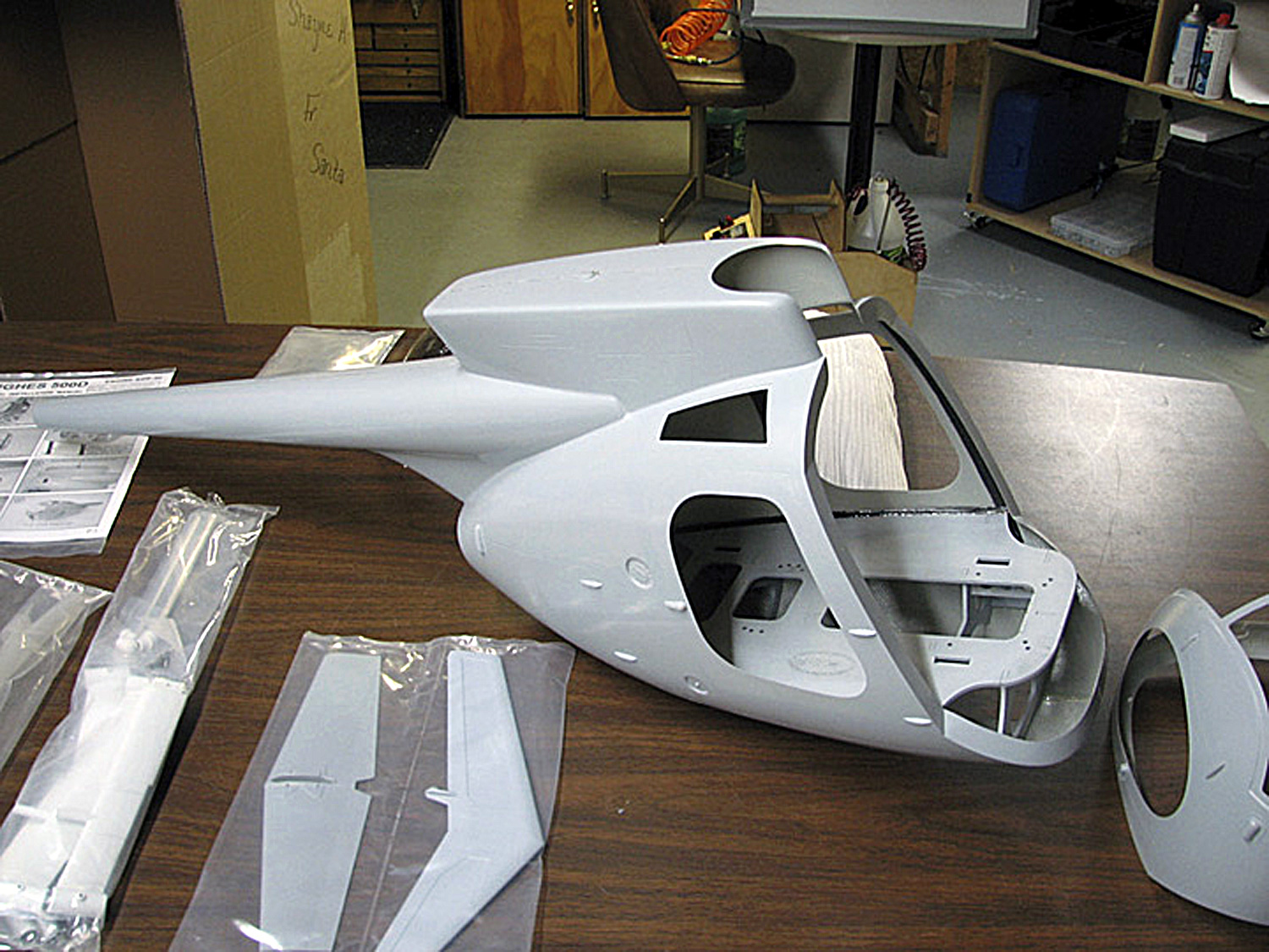 Close up view of Hughes 500D fiberglass fuselage on a table awaiting installation of mechanics