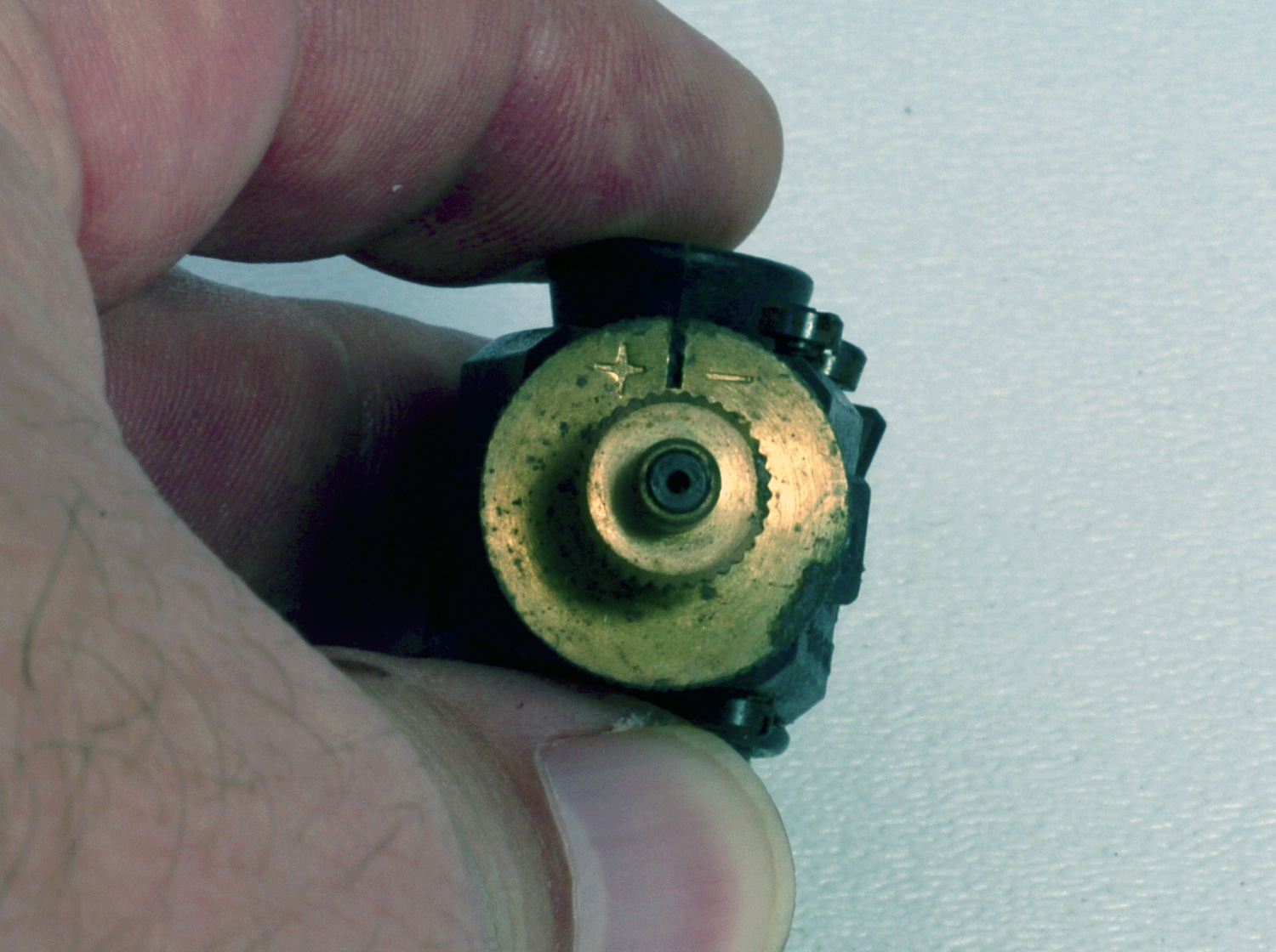 Close up photo of the mixture disk of an old school Perry carburetor
