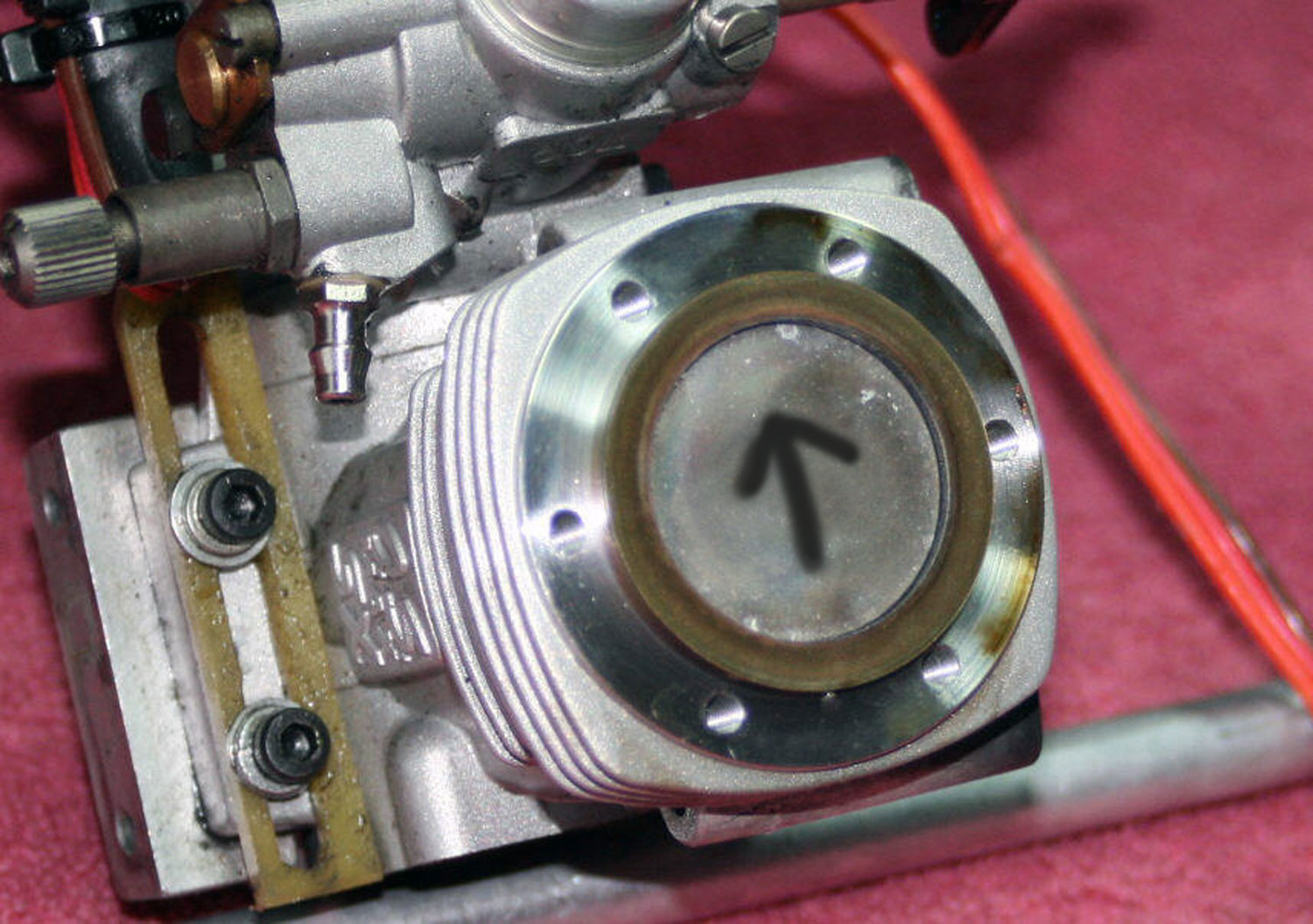 Close up photo of piston top with arrow indication direction for correct reassembly