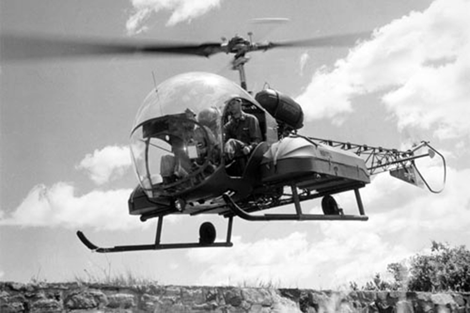 B;ack and white photo of Korean war vintage Bell-47 with litters on the sides for wounded transport