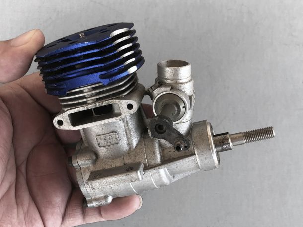 Photo of hand holding a gnarly used OS MAX 50SH-H engine in need of a clean up and new bearings.