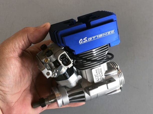 Photo of an OS MAX GT15HZII, a gasoline ignition engine which burns gasoline and oil premix for installation within a set of Audacity Models Pantera P6 mechanics through using an Audacity Models BBC-kit plus muffler