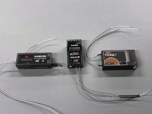 A shot of several brands of consumer-brand RC model receivers against a gray background